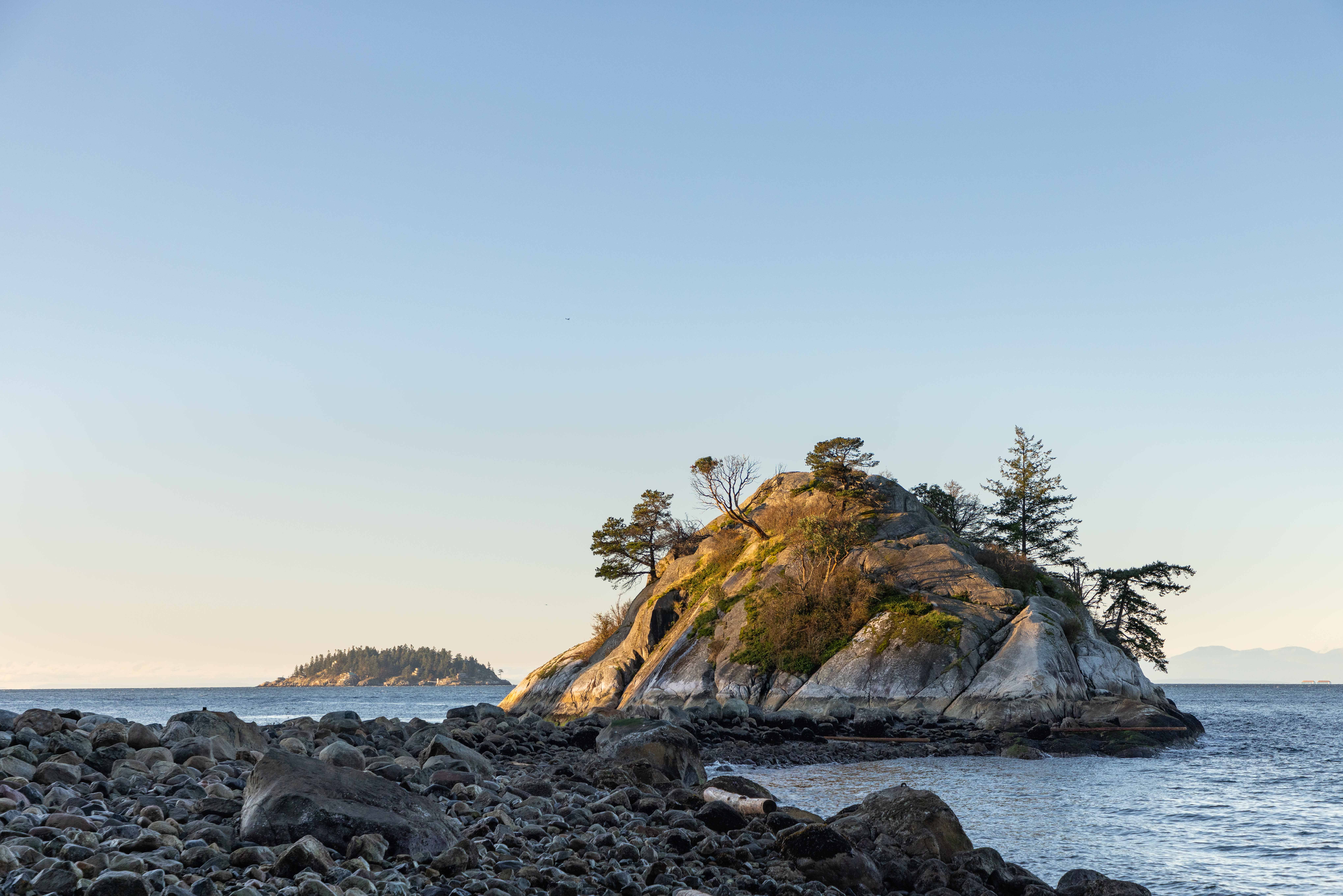 The rising sun shines on the rocky causeway at Whytecliff Park.